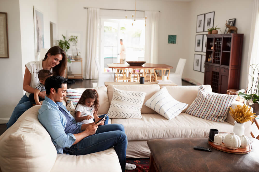 Young family sitting on sofa reading